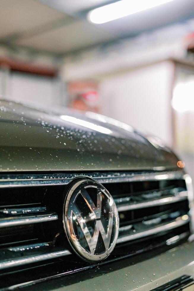 Budva, Montenegro - 25 December 2022. Wet hood of a car with a Volkswagen sign. Cropped photo