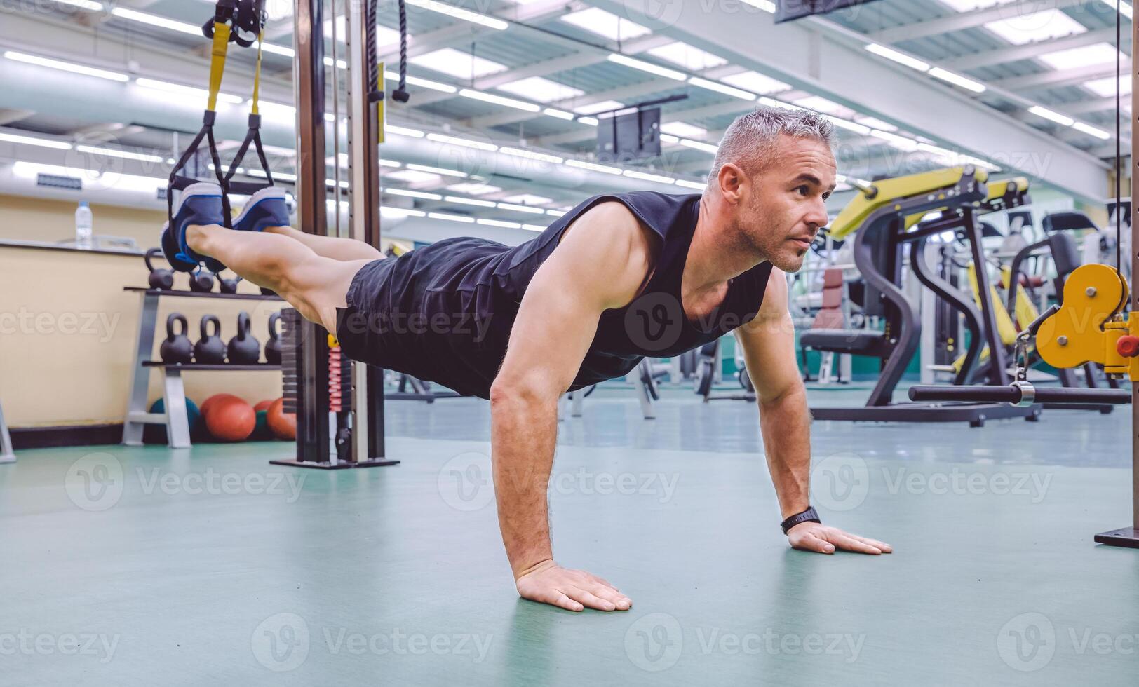 Man doing suspension training with fitness straps photo