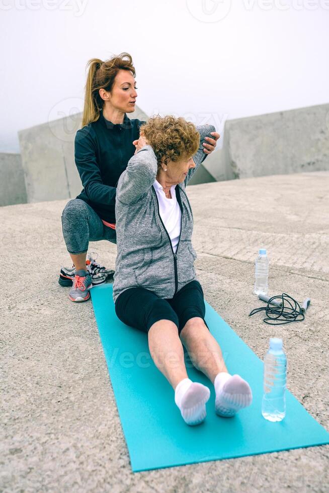 Young woman exercising with senior woman photo