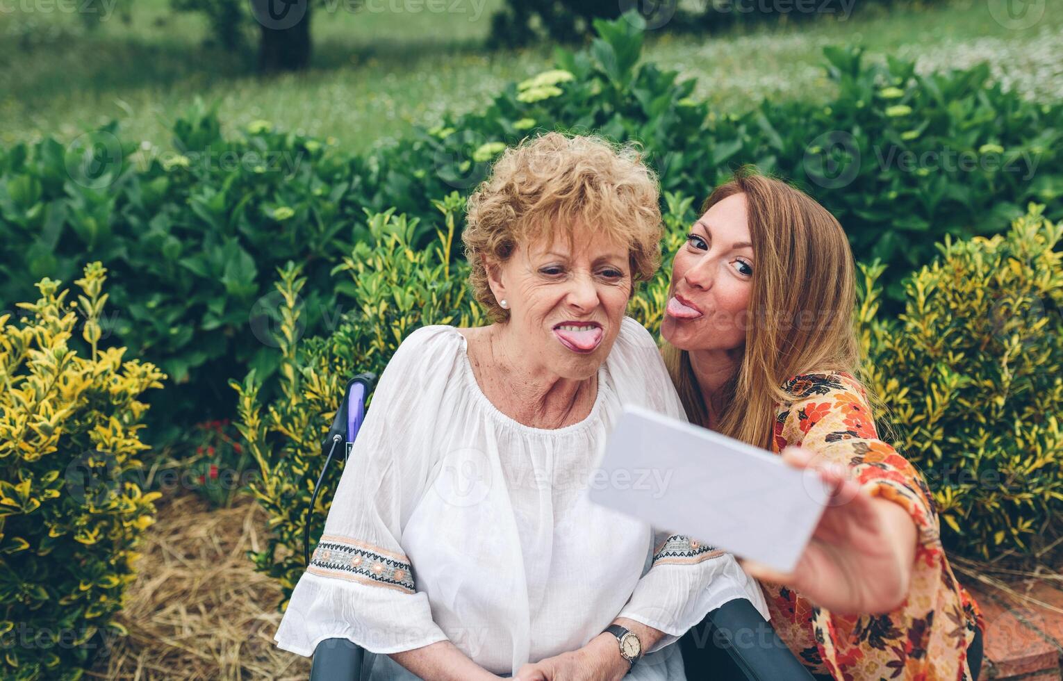 Girl taking selfie with her mother in wheelchair photo
