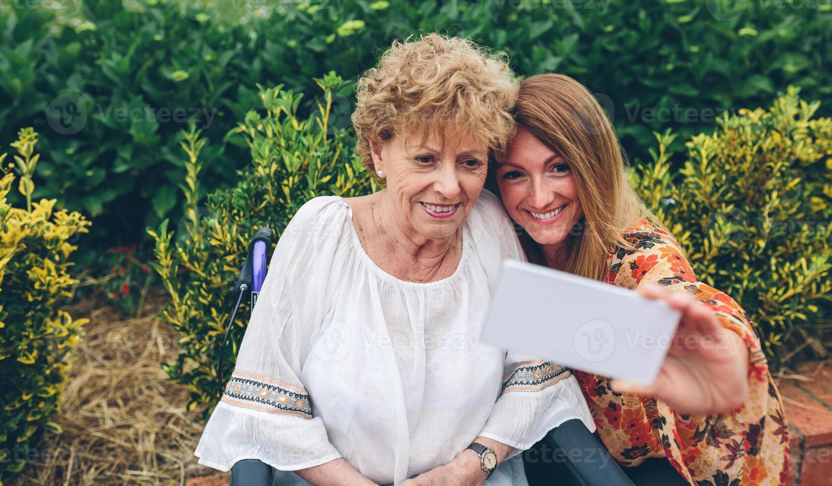 Girl taking selfie with her mother in wheelchair photo