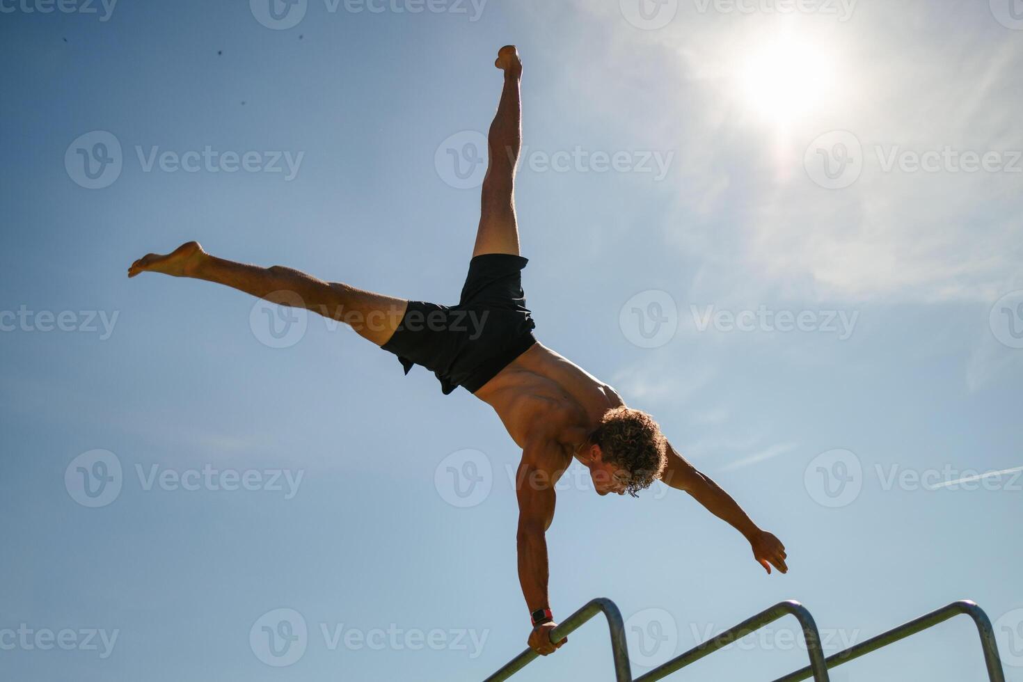Strong young sportsman doing calisthenics photo