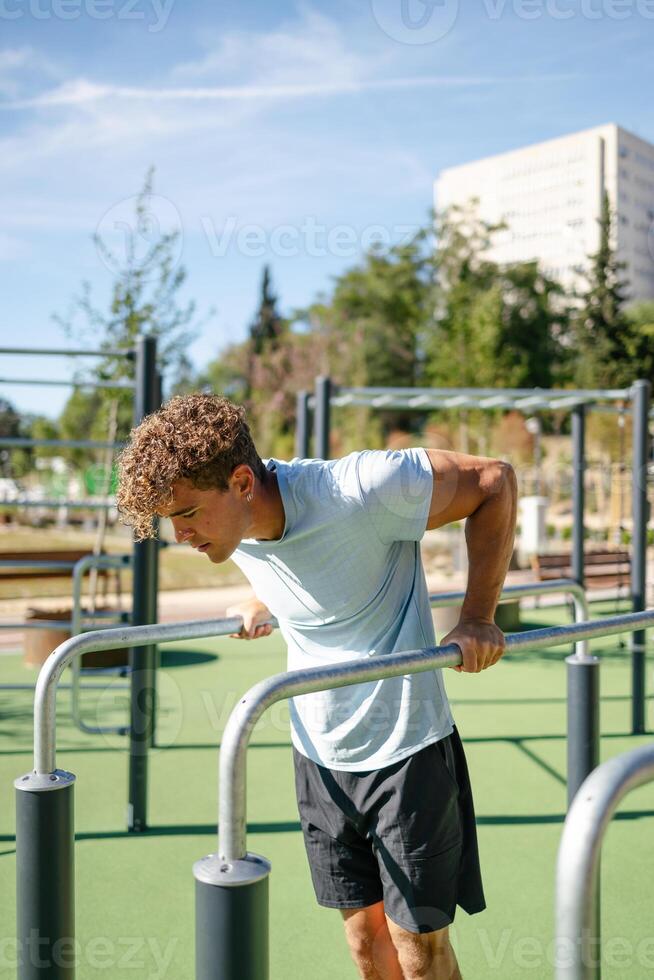 Strong young sportsman doing calisthenics photo