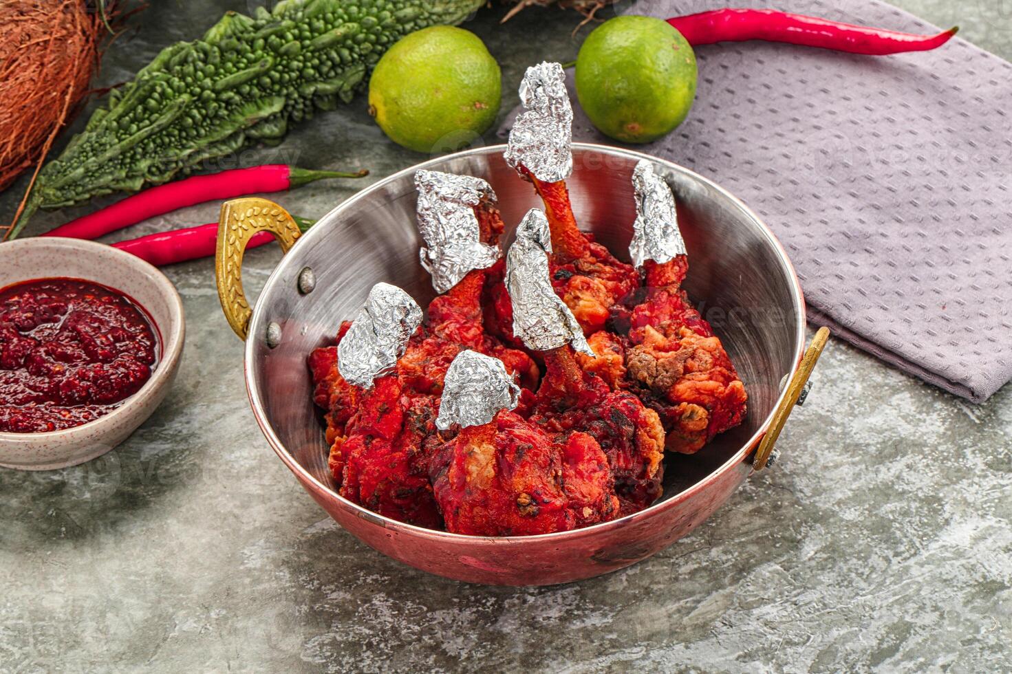 A bowl of chicken with spices and a bowl of lime photo