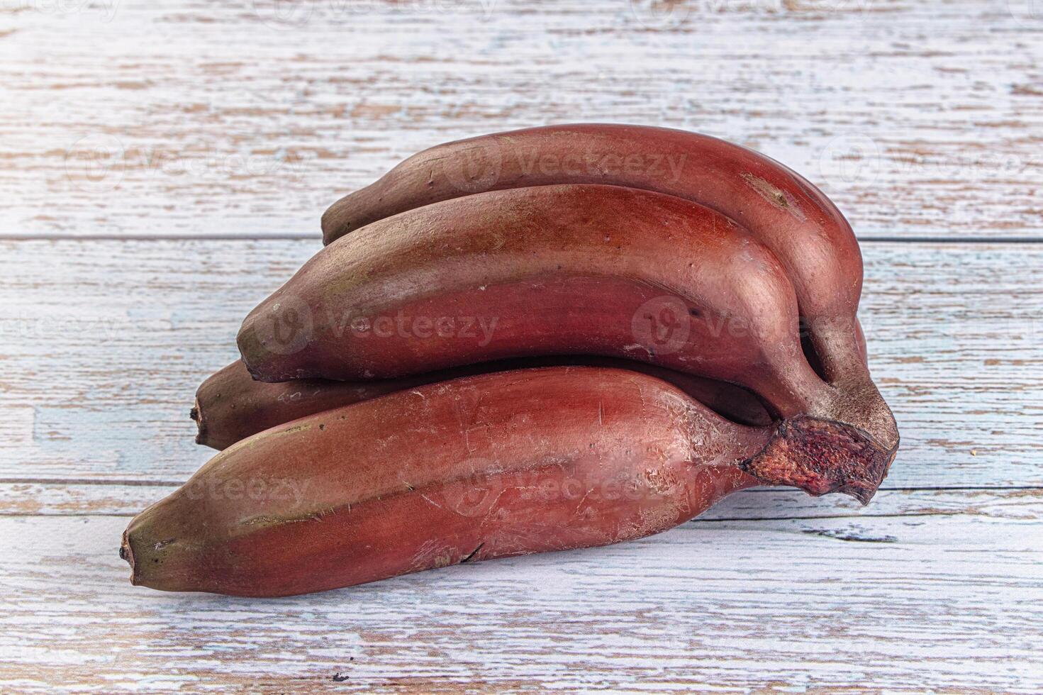 A pile of bananas on a wooden table photo