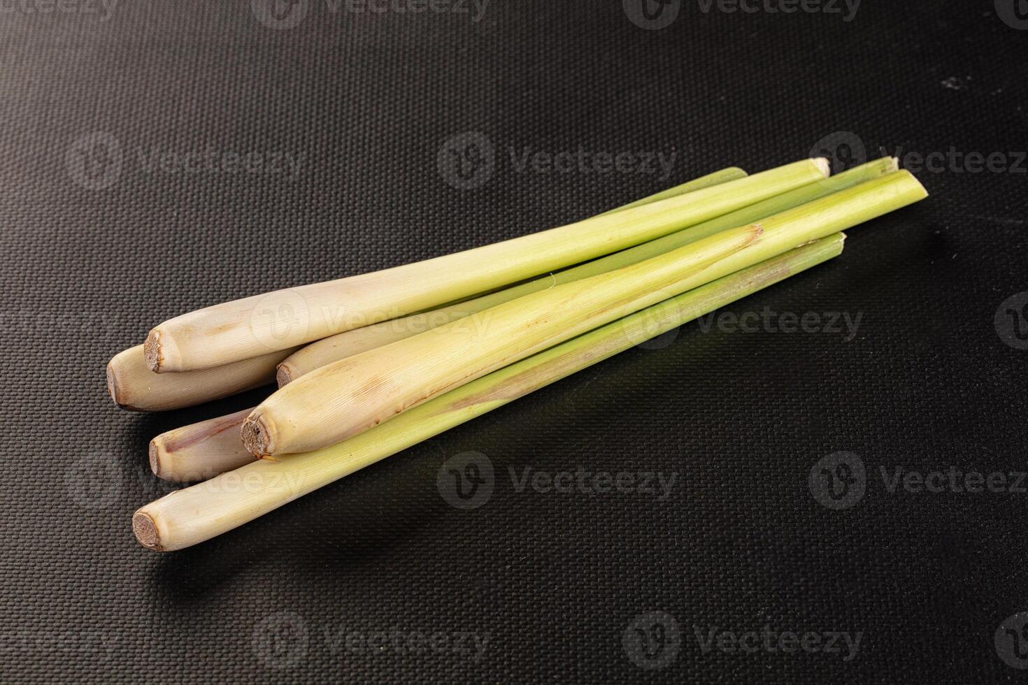 Three pieces of green stalks on a black surface photo