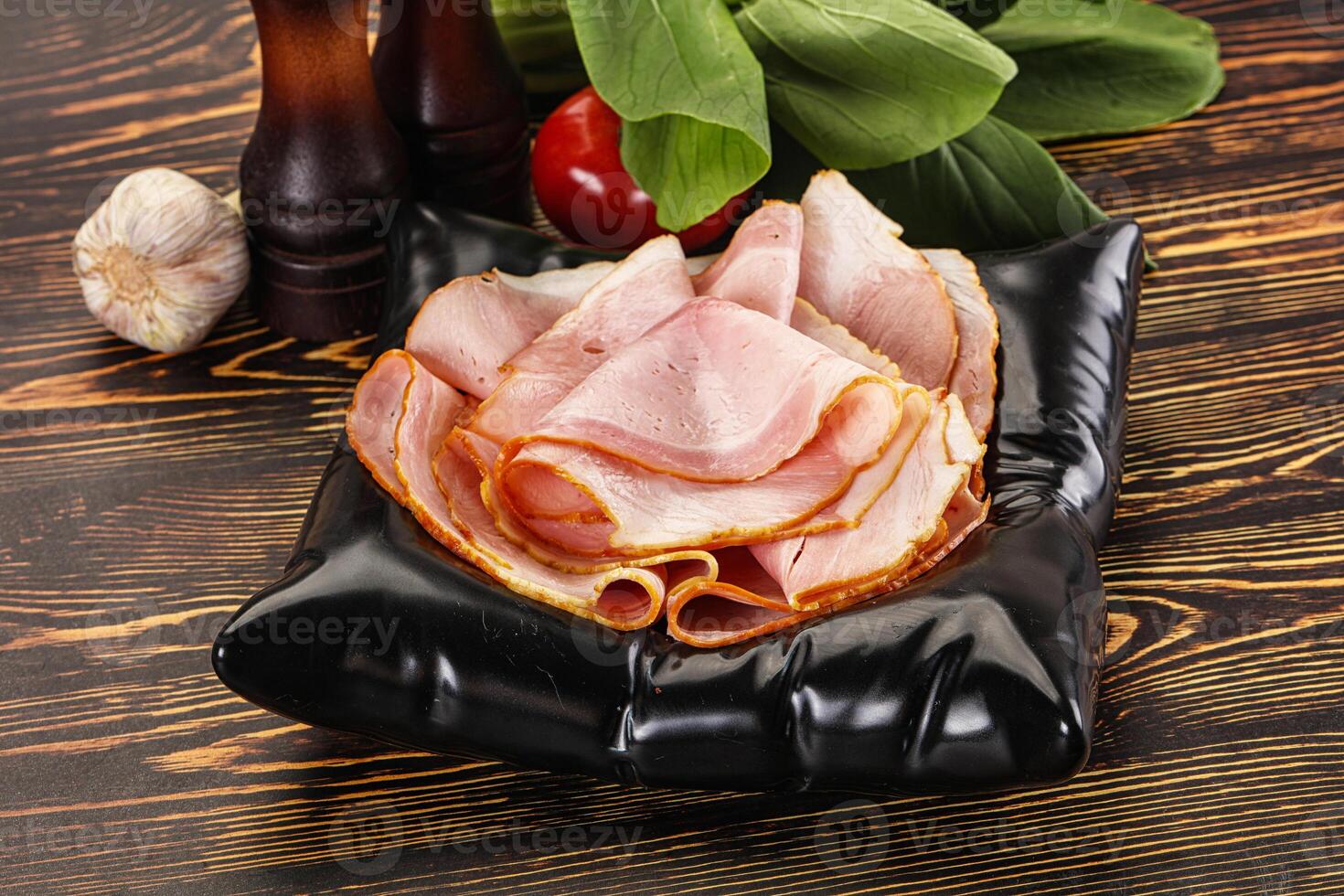 A plate with ham and vegetables on it photo