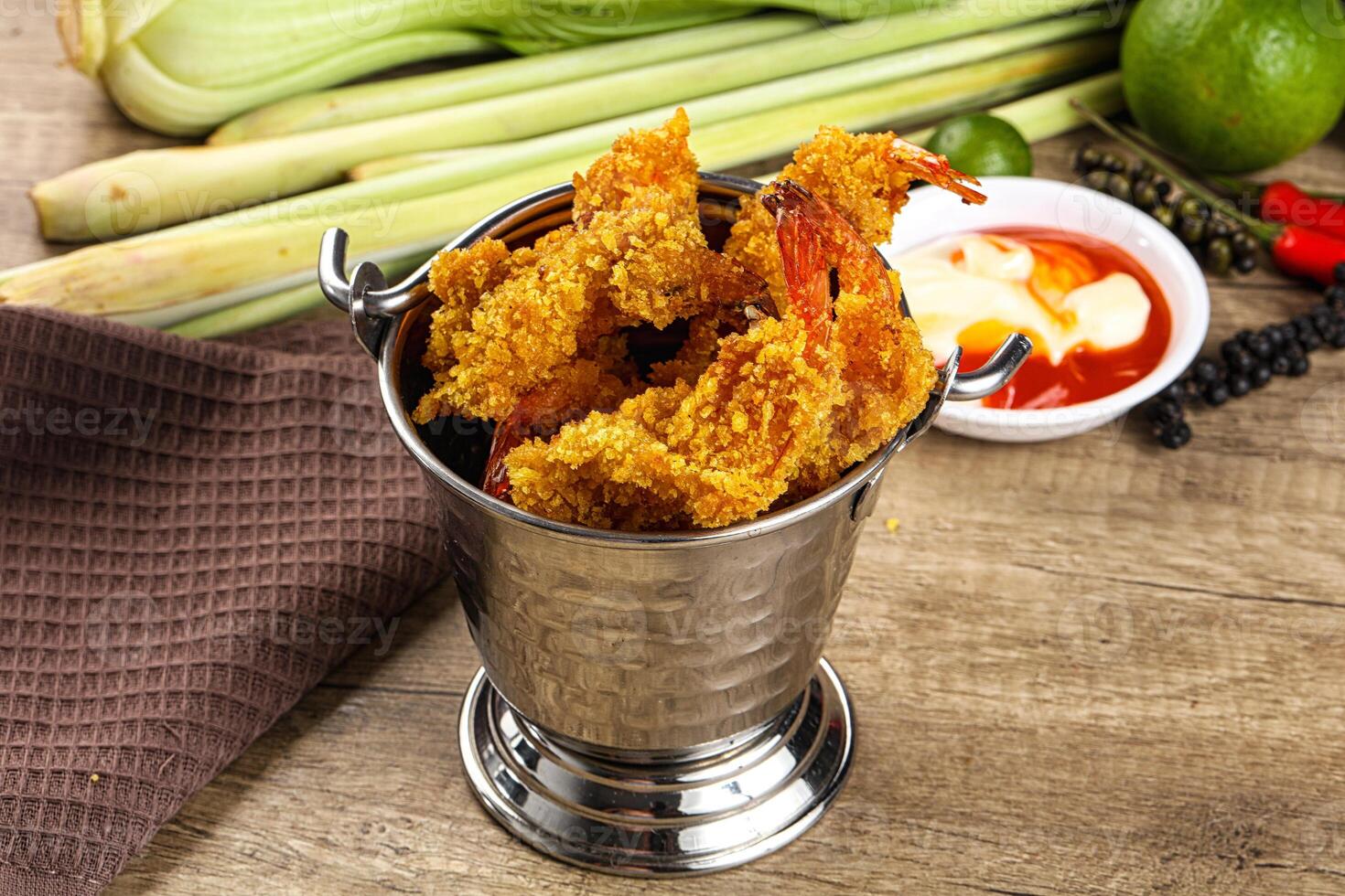 A silver metal container with fried shrimp and other food photo