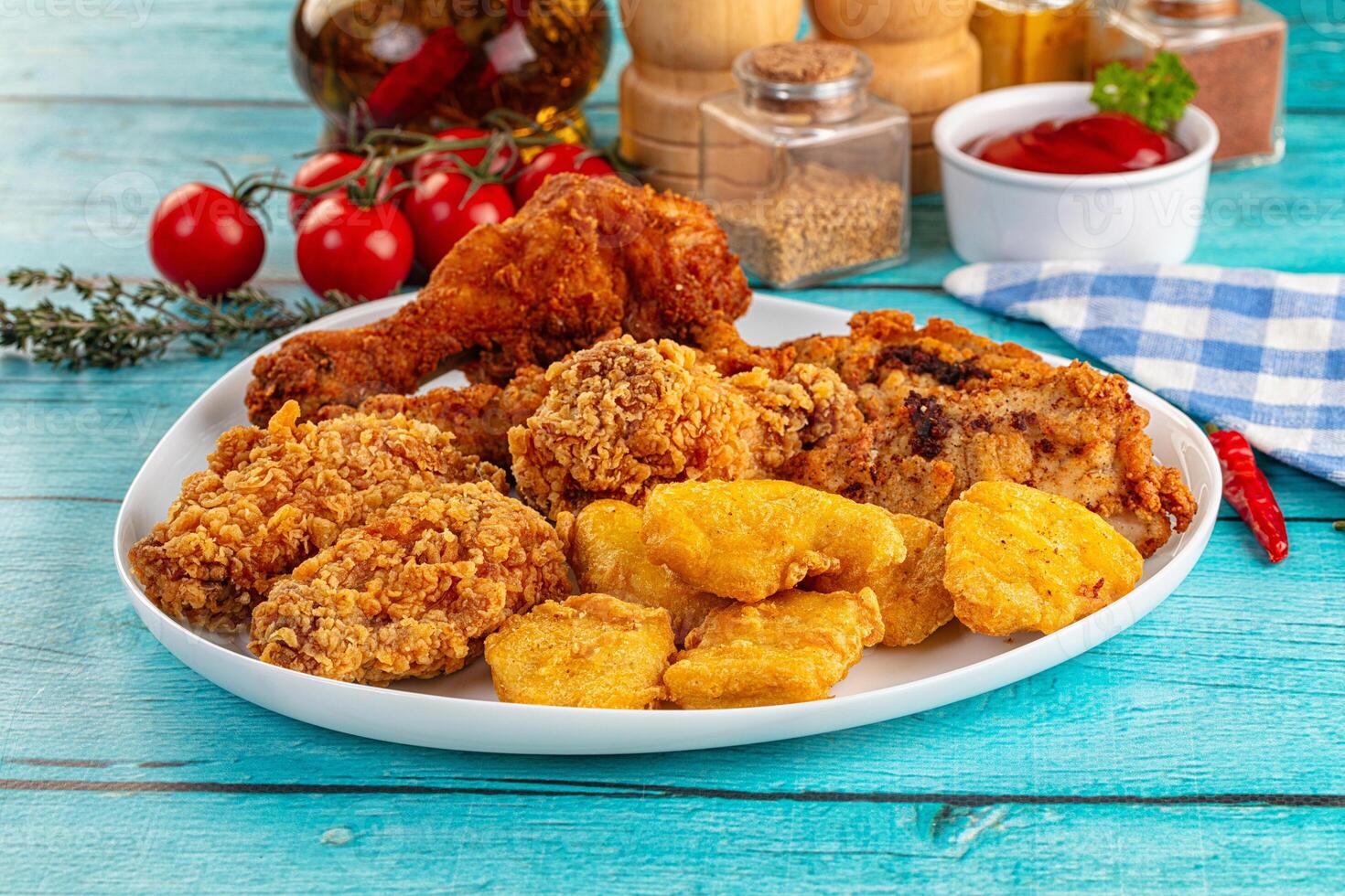 A plate of fried chicken and other food on a table photo