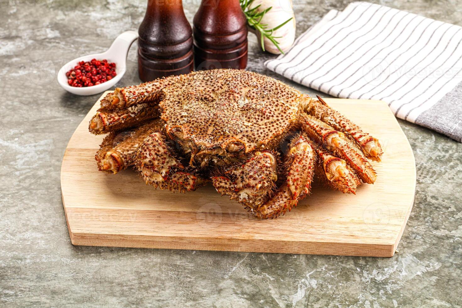 A crab on a cutting board with a bottle of beer photo
