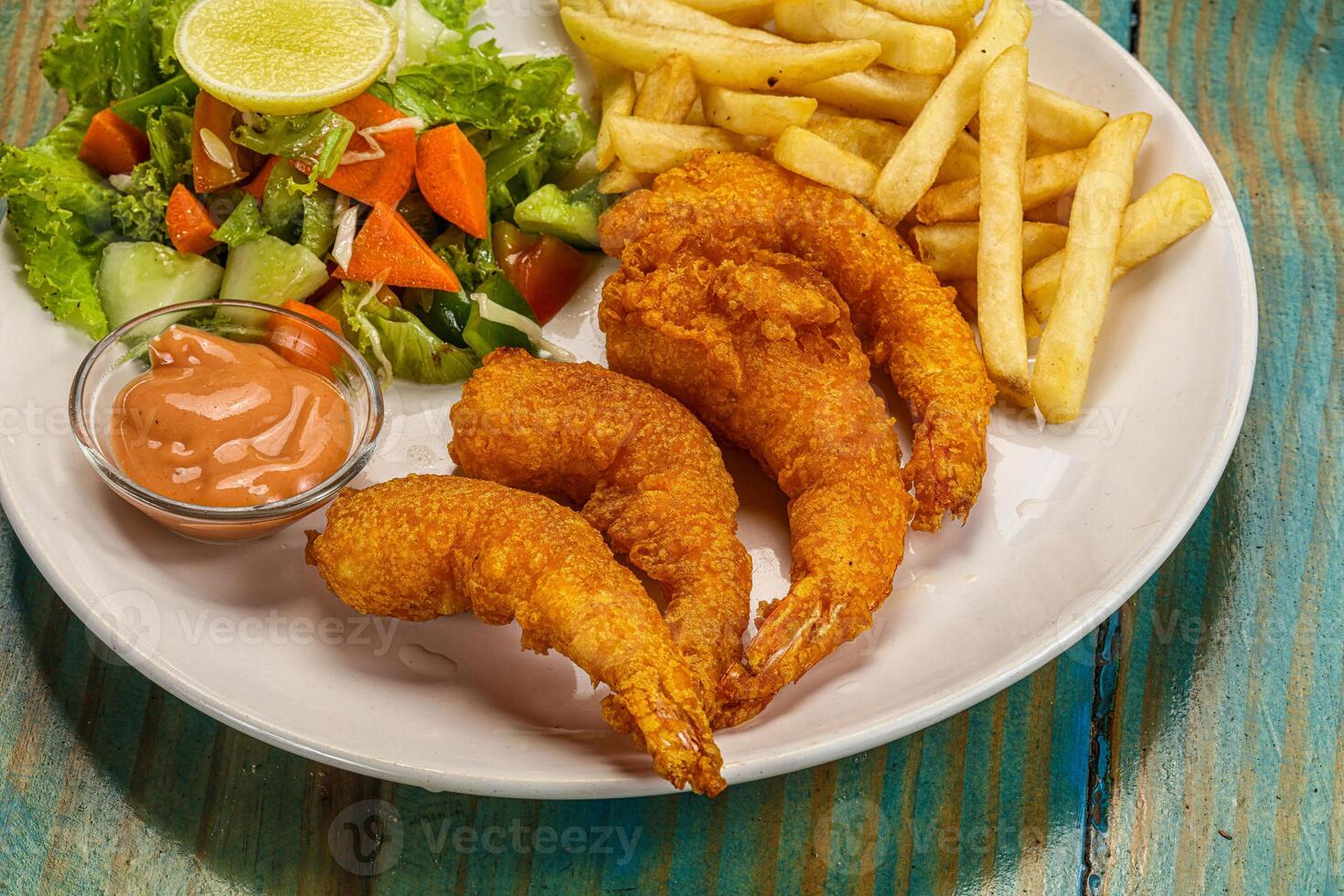 Fried shrimp and french fries on a white plate photo