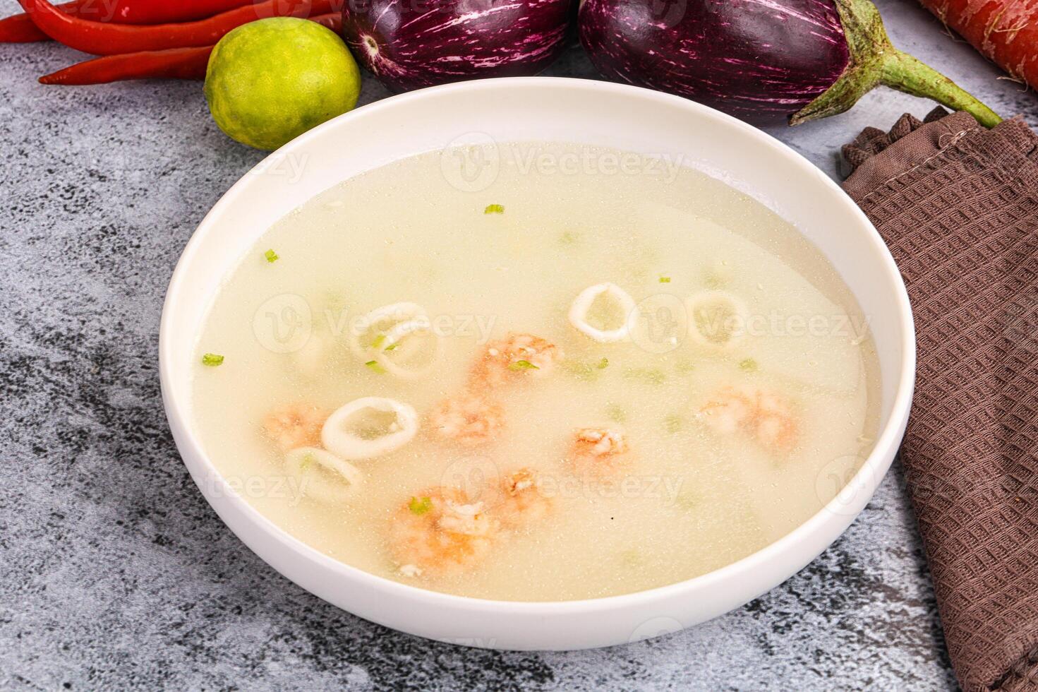 A bowl of soup with vegetables and seafood photo