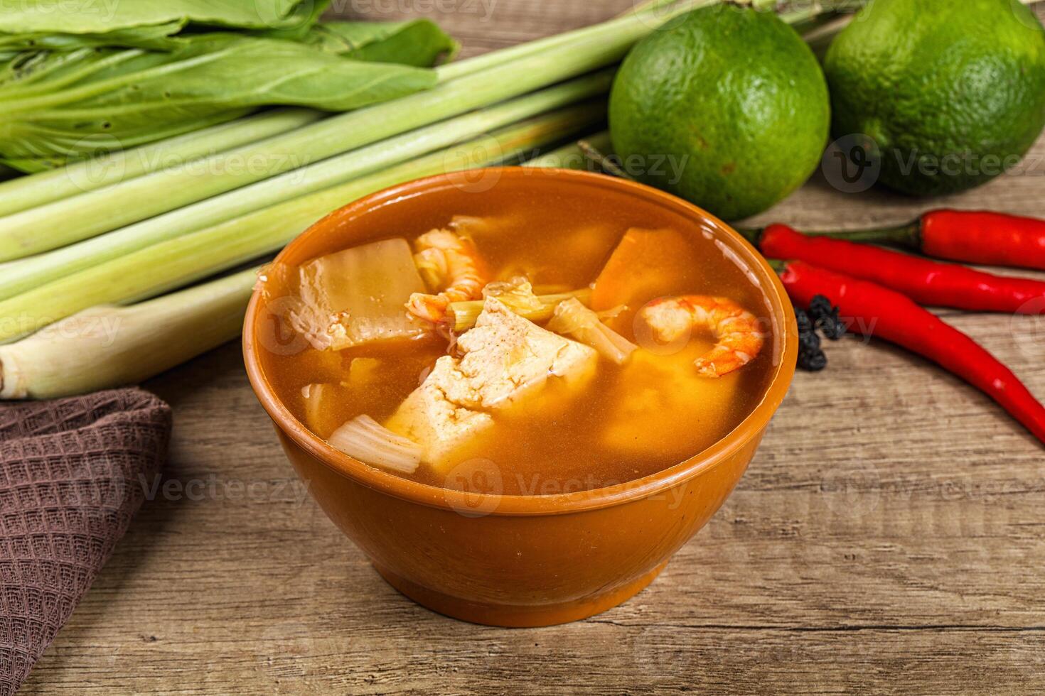 A bowl of soup with a bowl of vegetables and a knife photo