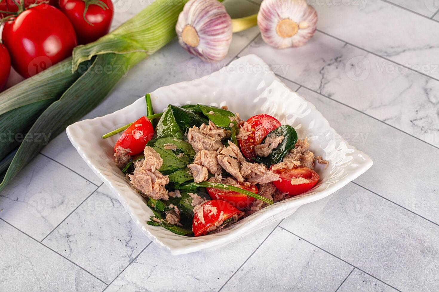 A bowl of tuna salad with tomatoes and spinach photo
