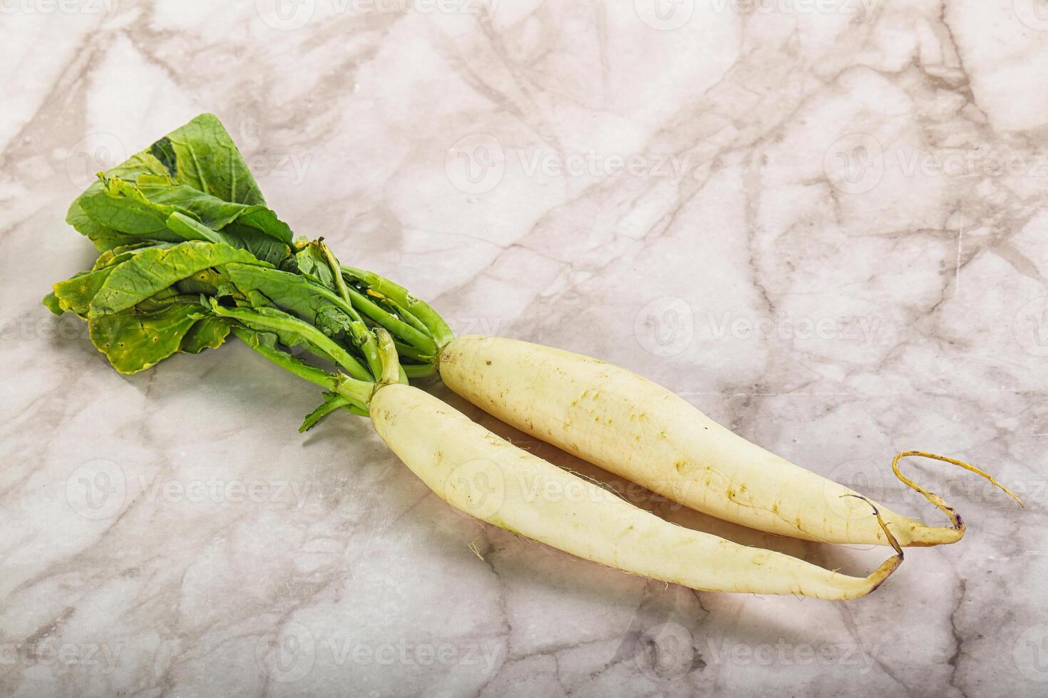 Two radishes on a marble surface photo
