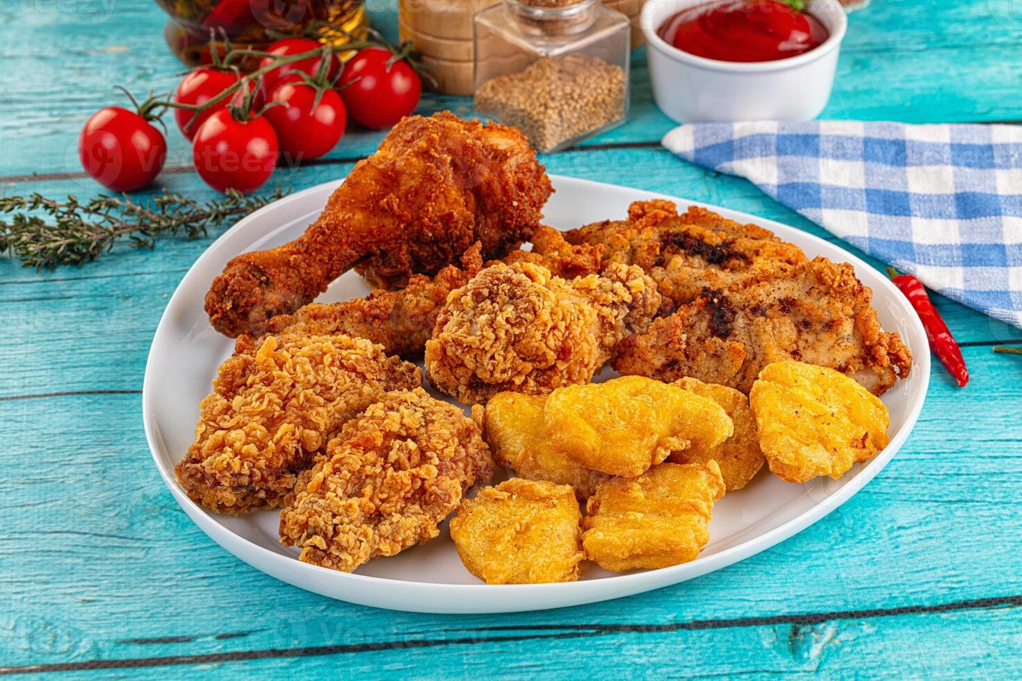 A plate of fried chicken, mashed potatoes and tomatoes photo