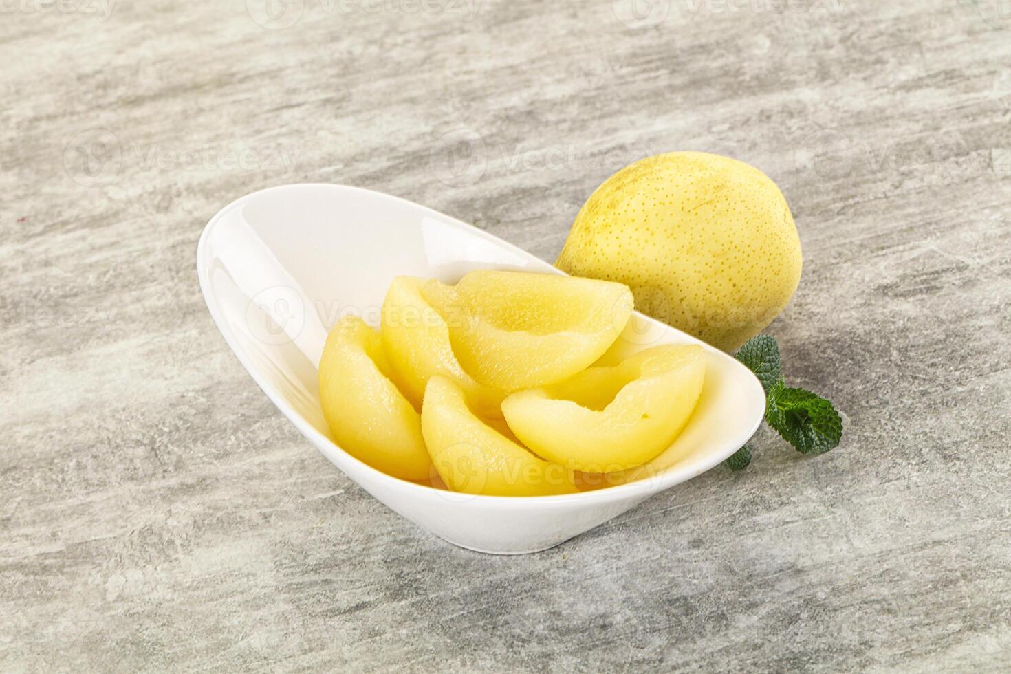 A bowl of sliced yellow peaches on a table photo