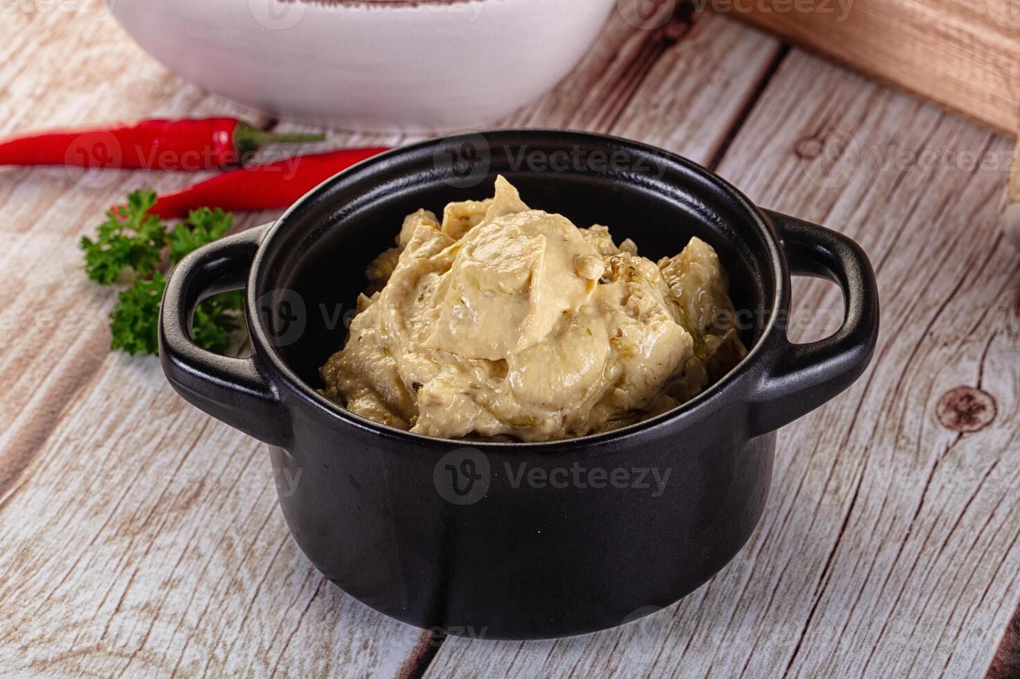 A bowl of mashed potatoes sits on a wooden table photo
