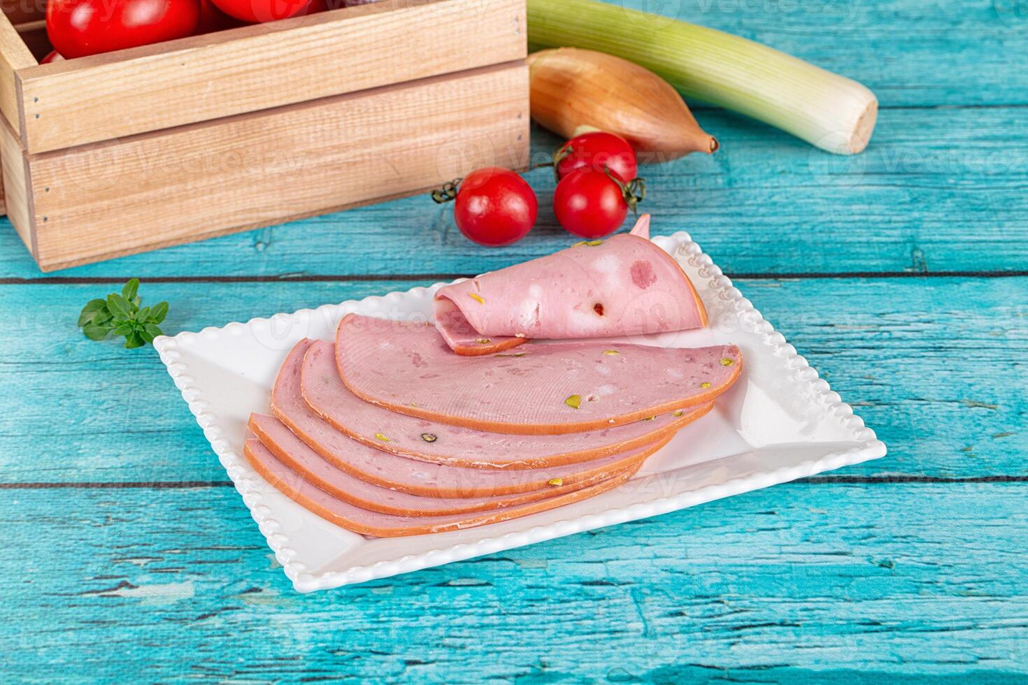 Sliced ham on a plate with tomatoes and onions photo