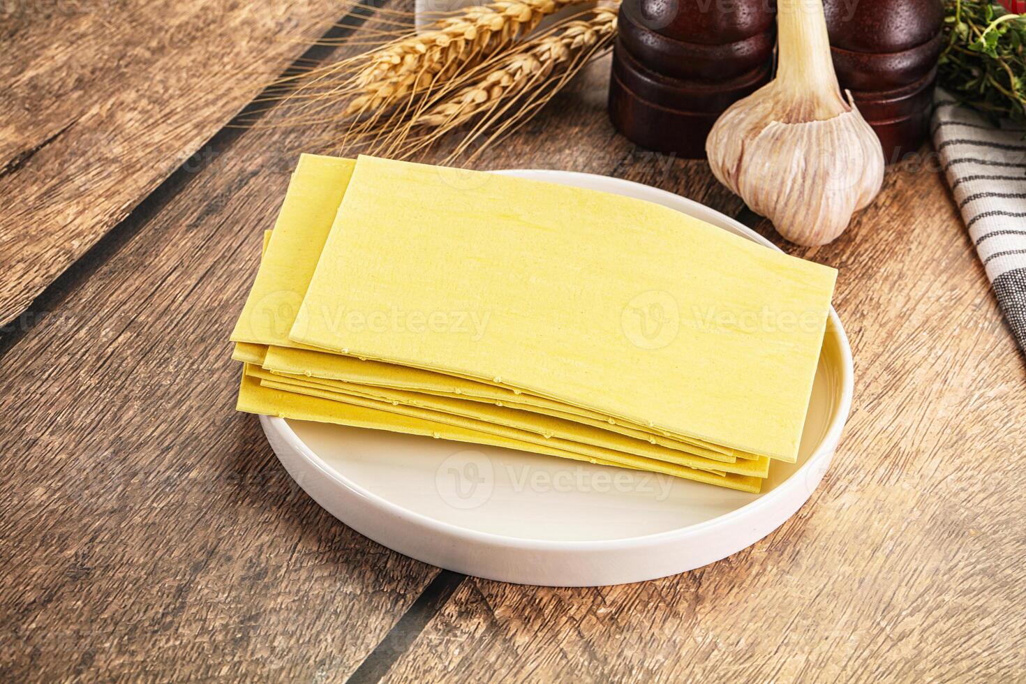 A plate of cheese on a table next to a bowl of garlic photo
