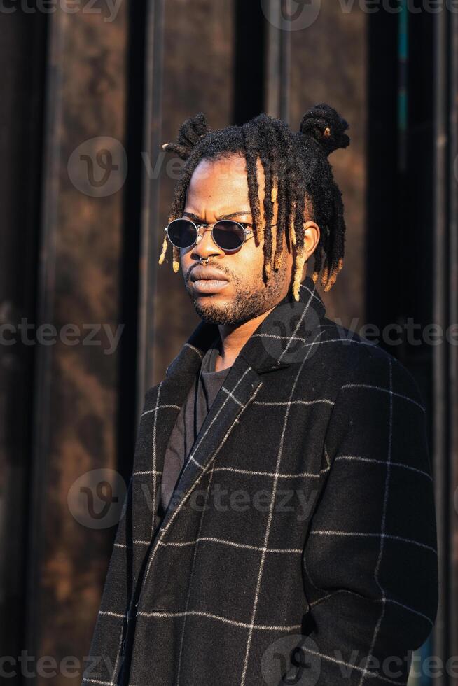Stylish black man with dreadlocks in buns photo