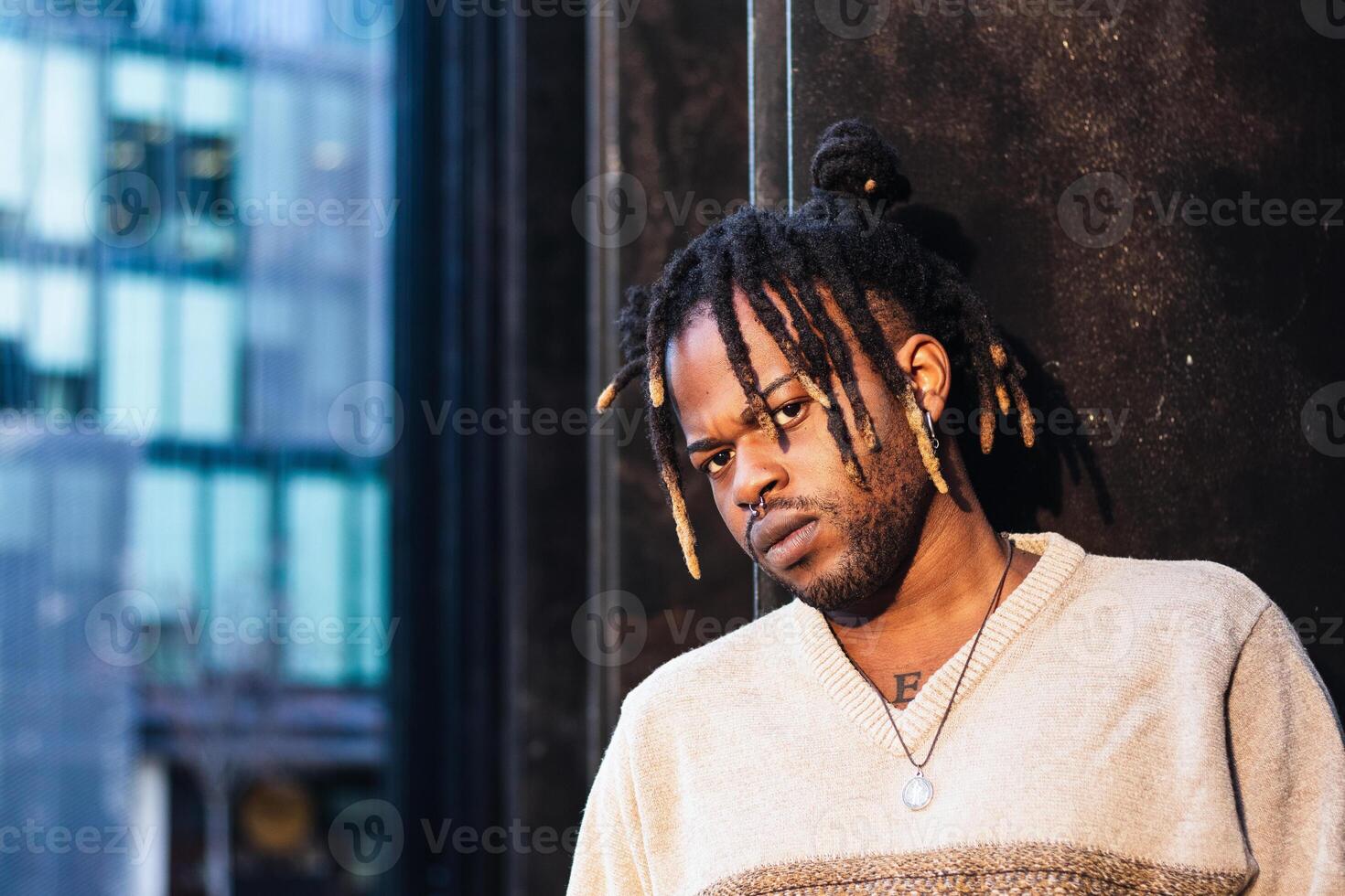 Stylish black man with dreadlocks in buns photo