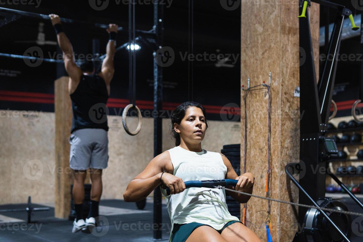 Hispanic sportswoman exercising on rowing machine photo