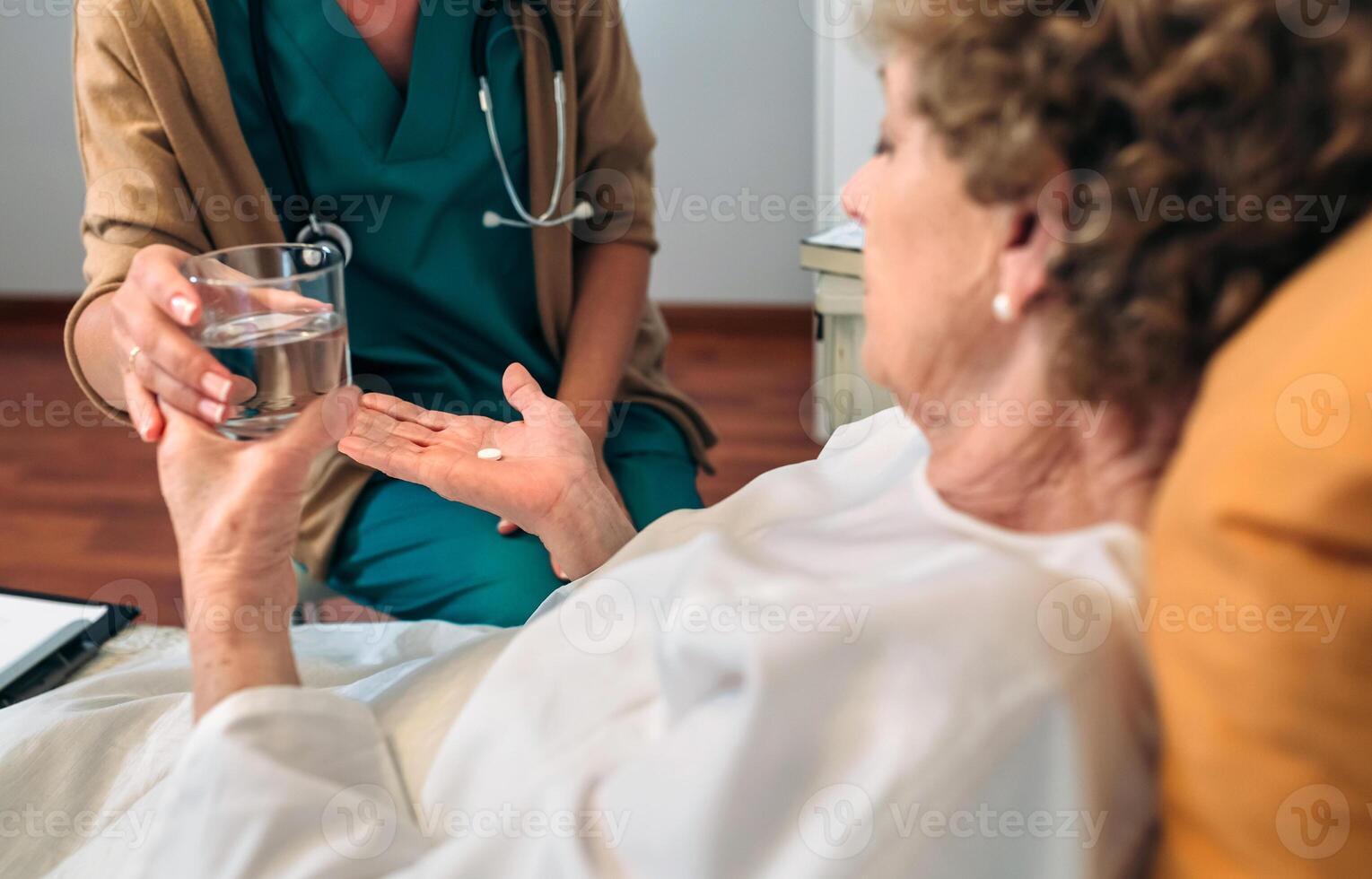Doctor giving medication dose to elderly patient photo