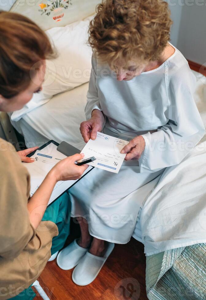 Doctor giving a prescription to senior patient photo