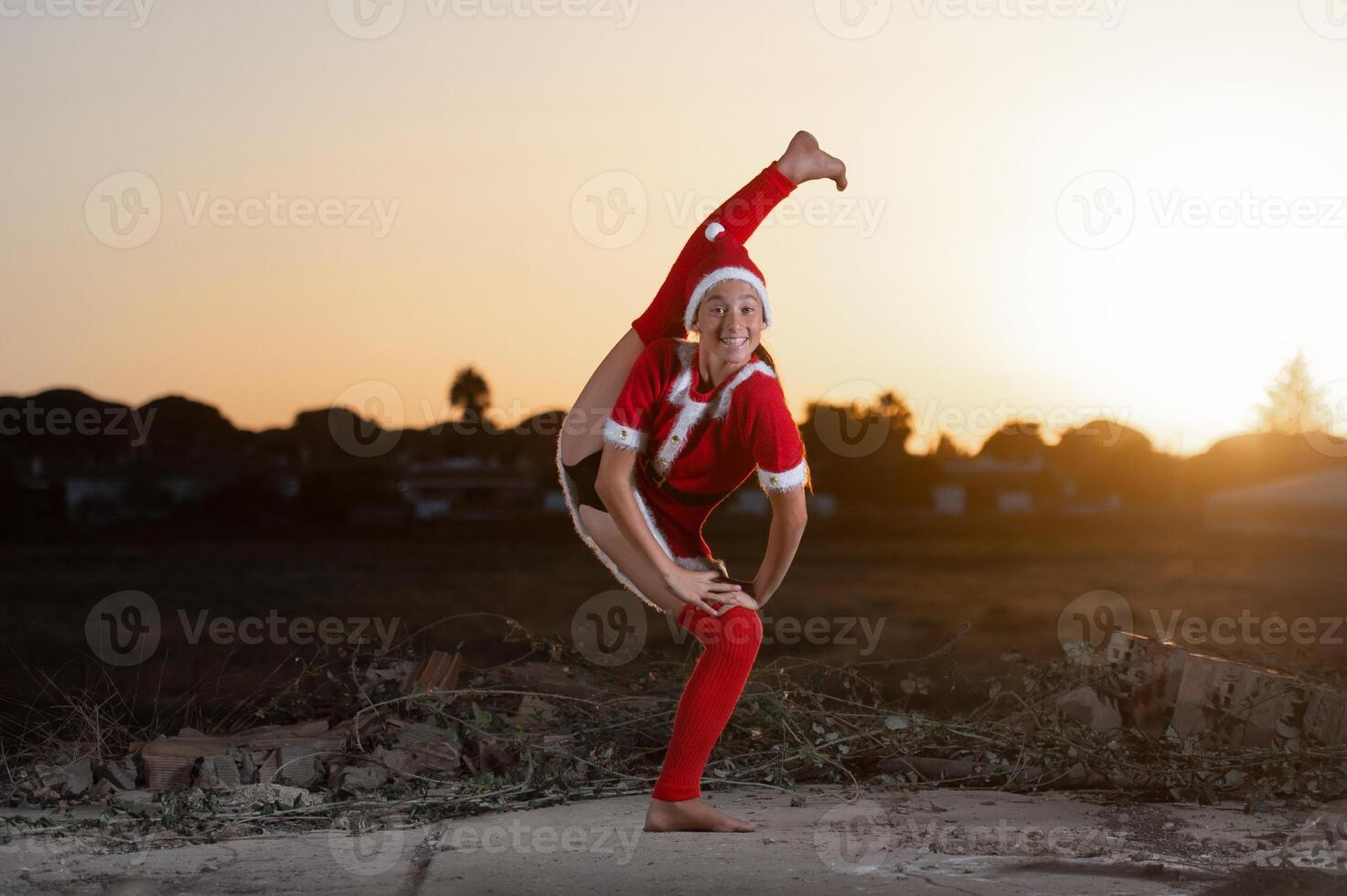 young girl performing rhythmic gymnastics exercises wearing santa claus dress photo