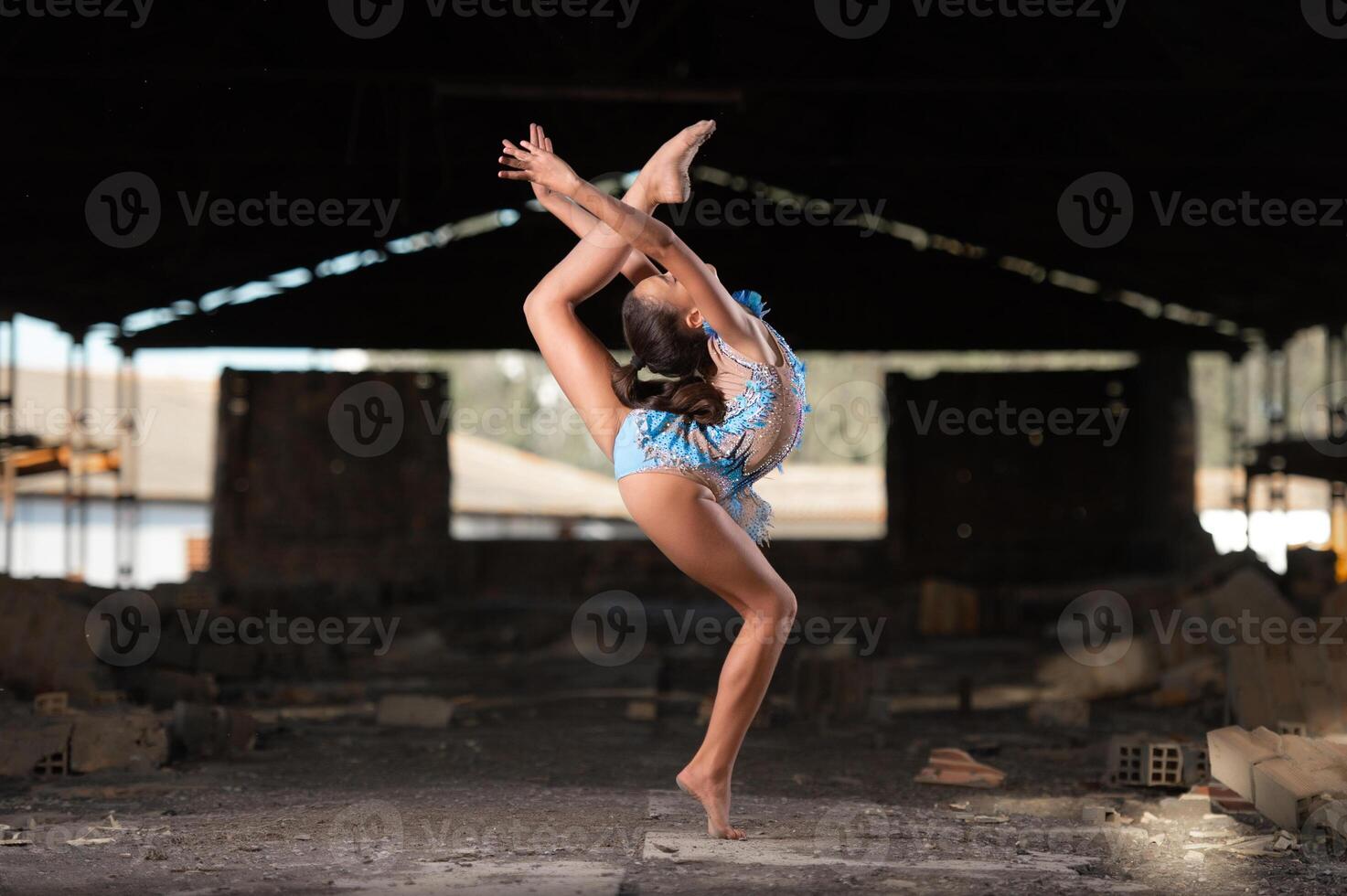 Young girl performing rhythmic gymnastics exercises outdoors photo