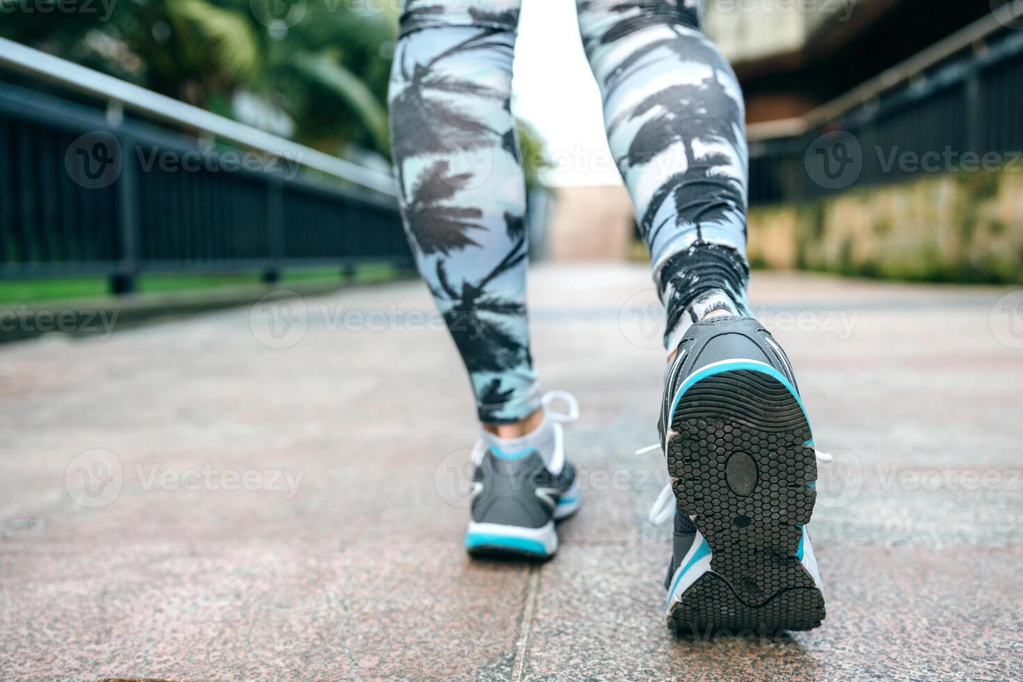 Woman legs ready to run wearing sneakers and tropical leggings photo