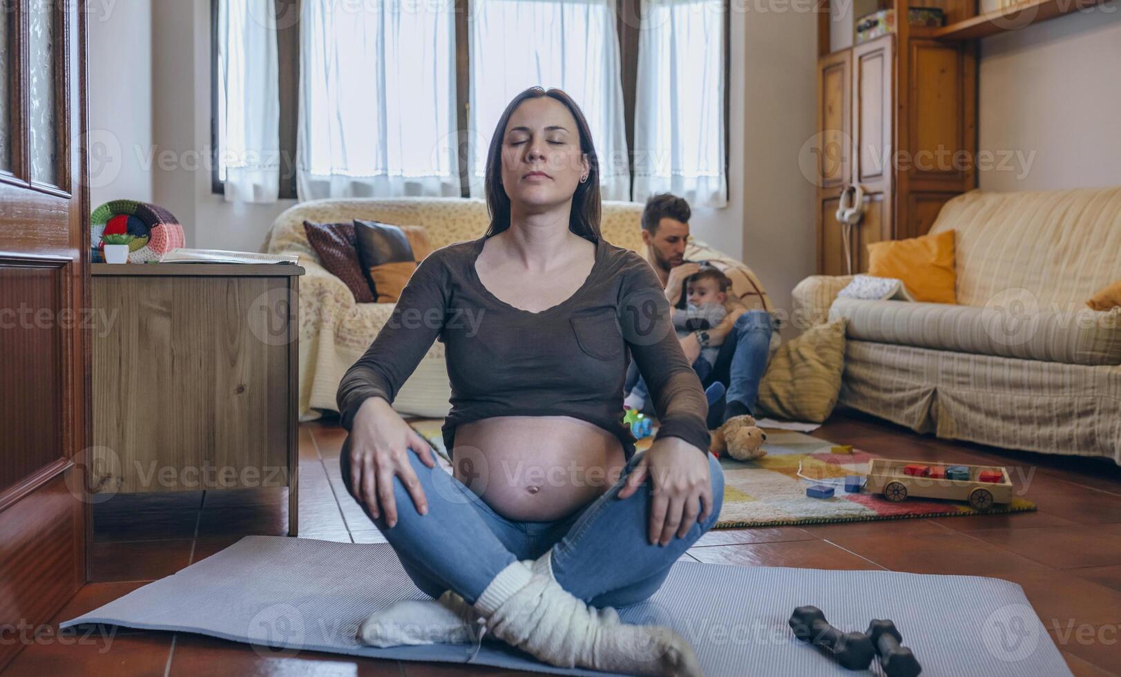 Pregnant woman exercising in the living room photo
