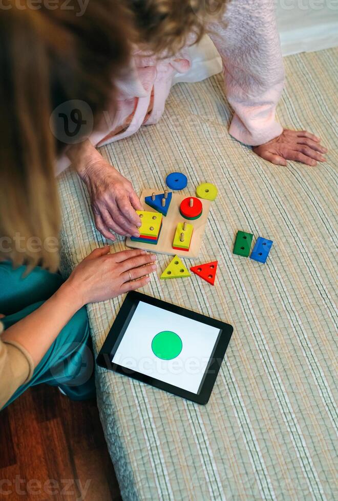 Female doctor showing geometric shapes to elderly patient photo