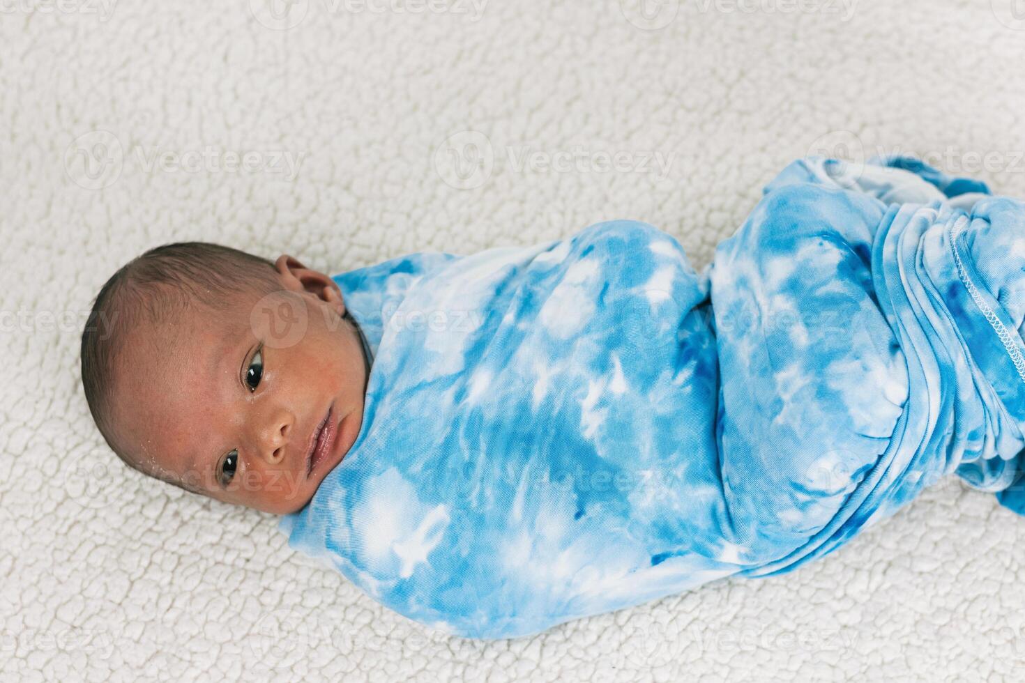Newborn baby wrapped on soft blanket photo