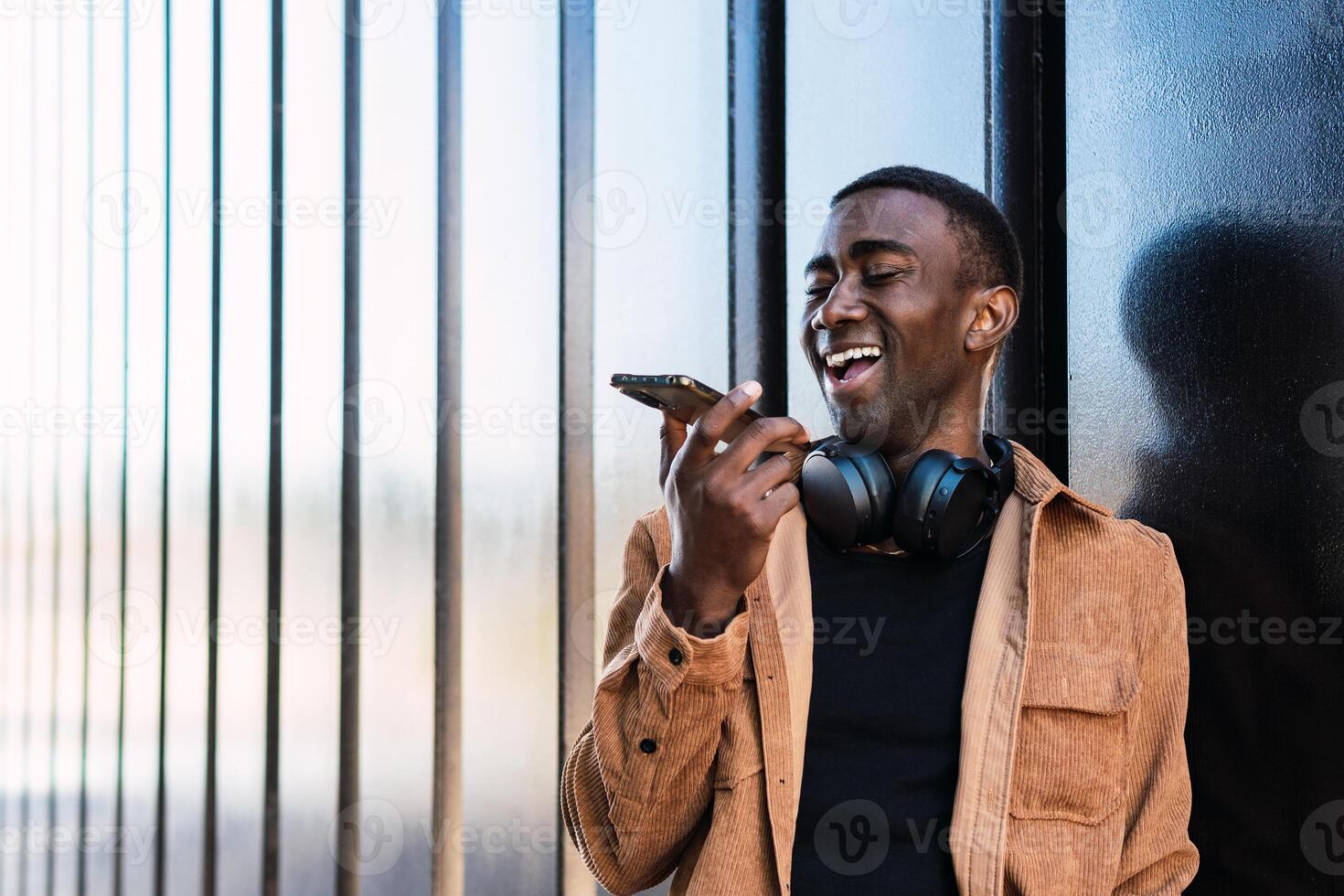 Black man with headphones recording audio message photo