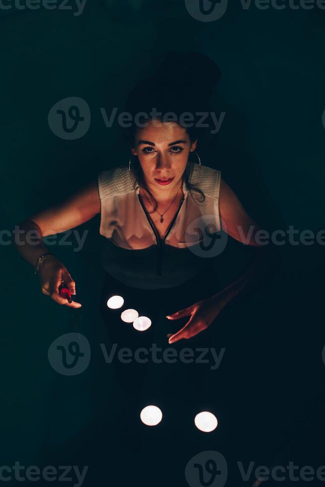 Woman swimming in pool with candles photo