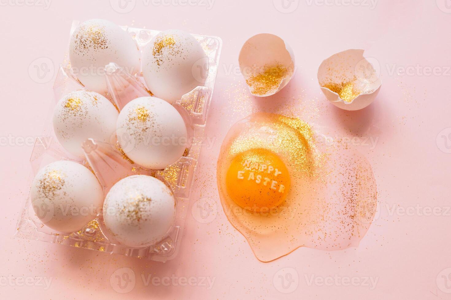 Festive Easter eggs in box and broken egg on table photo