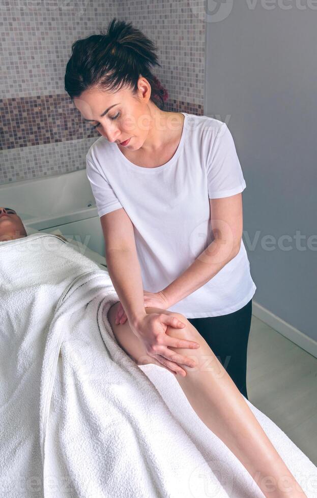 Massage therapist doing lymphatic drainage treatment to woman photo