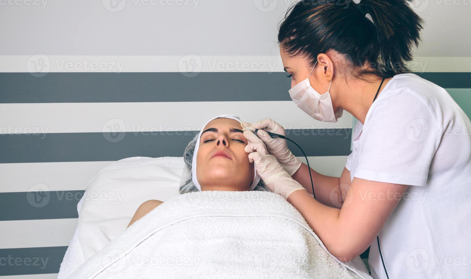 Female doctor doing getting rf lifting to woman in clinic photo