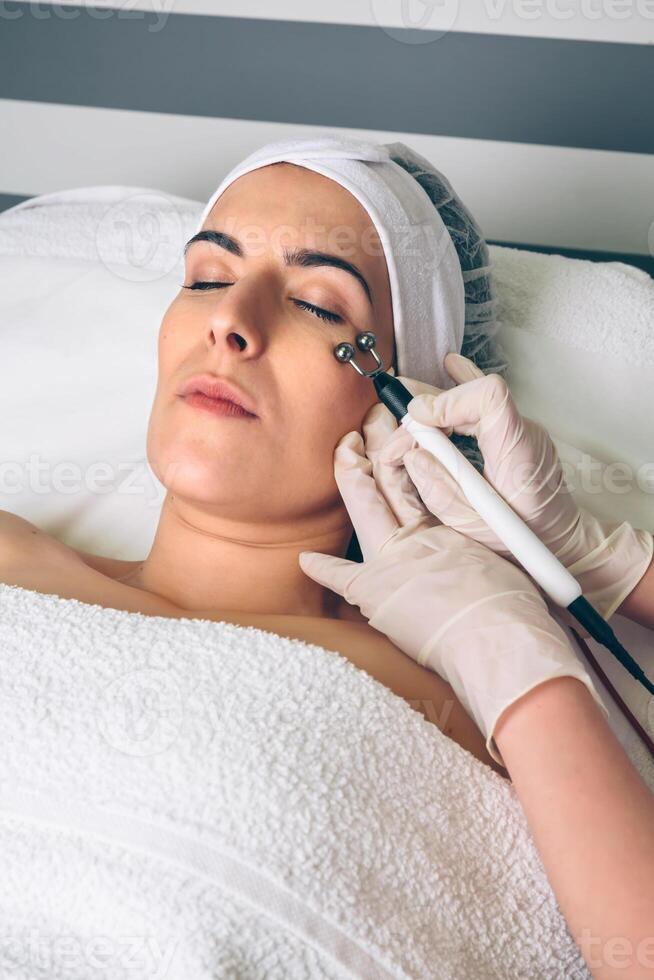 Woman getting rf lifting around of eyes in clinic photo