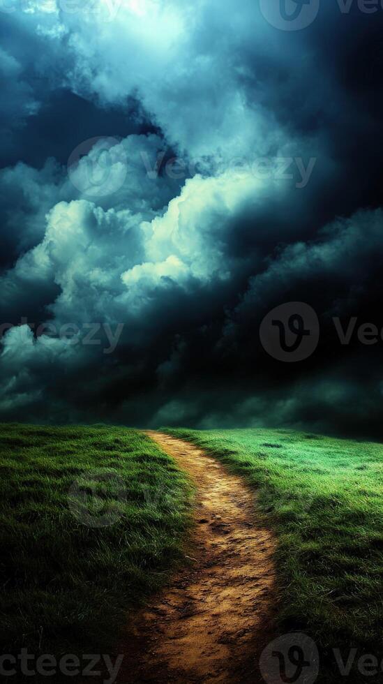 A dirt path leads to a dark sky with clouds photo