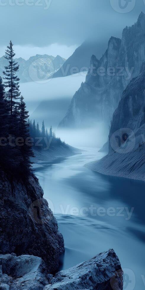 A river flows through a mountain range with trees photo