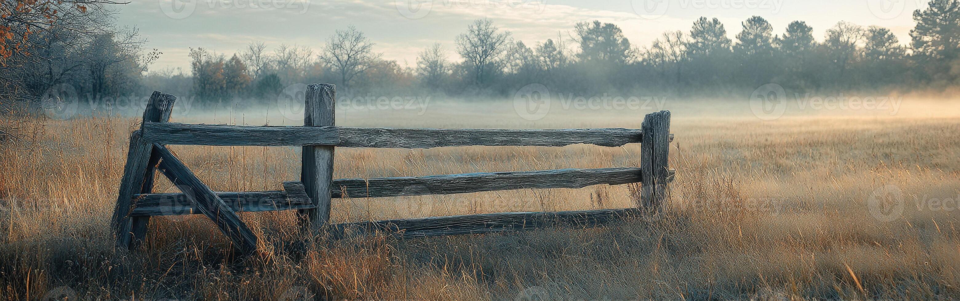 A wooden fence in a field with fog photo