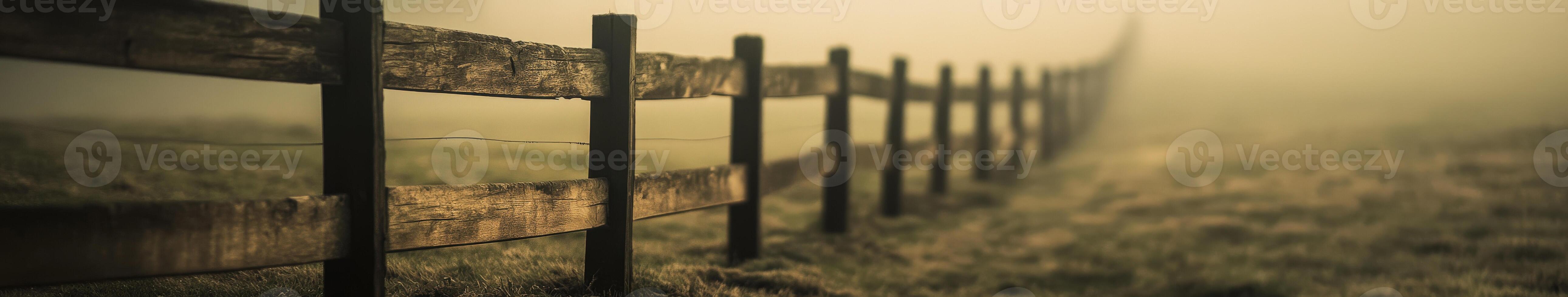 A fence is shown in the fog on a field photo