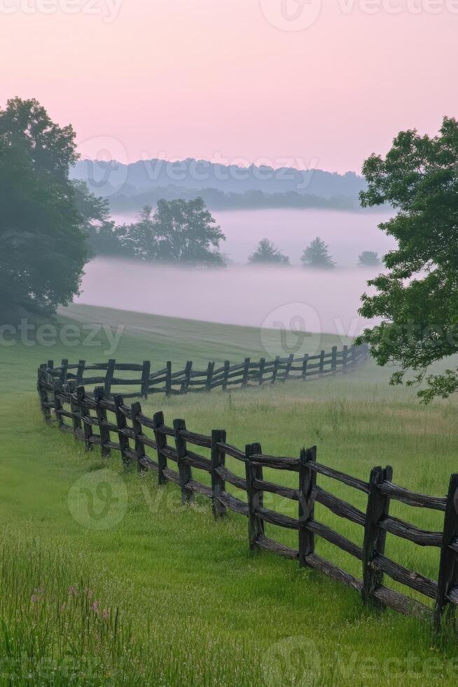 A fence is in the foreground of a grassy field photo