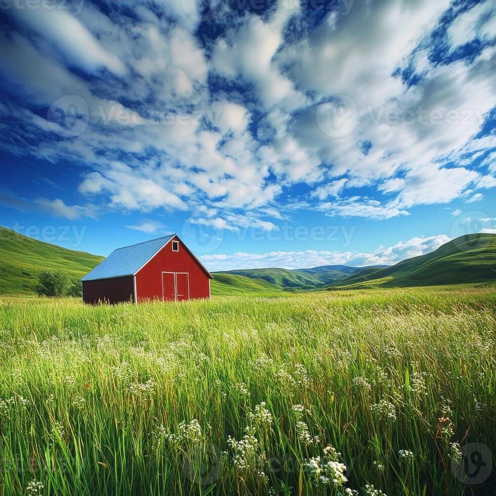 A red barn in a green field with blue skies photo
