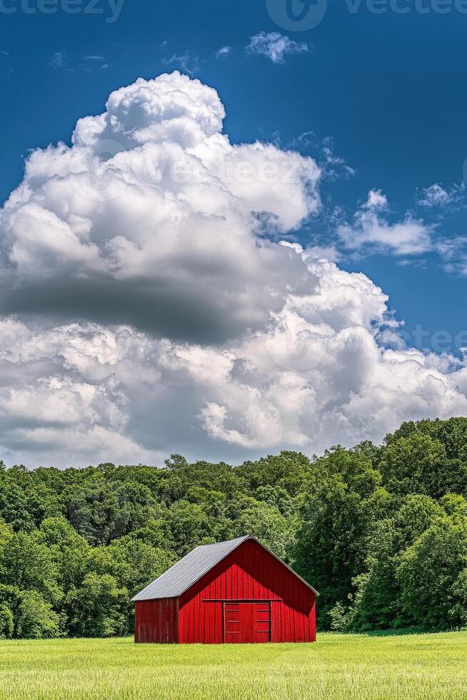 A red barn sits in a green field with trees and clouds photo