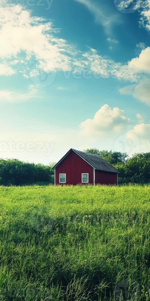 A red barn in a field with a blue sky photo