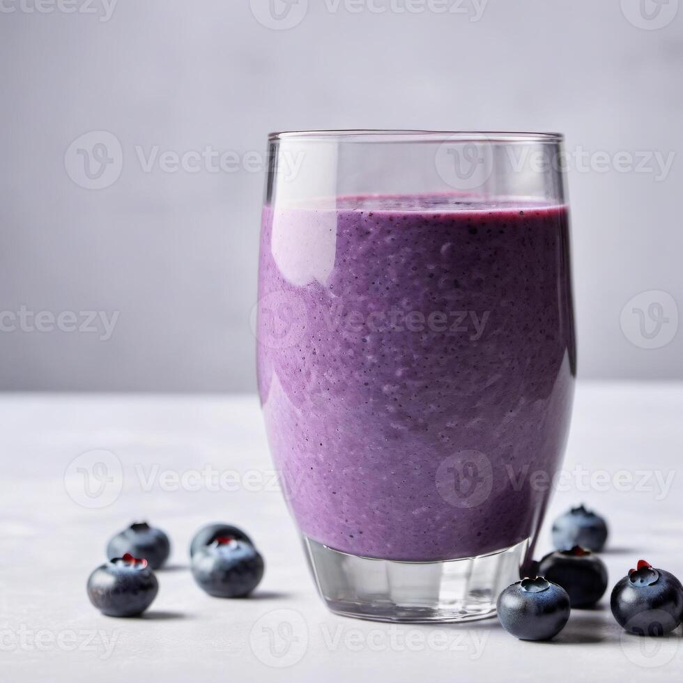 Glass of blueberry smoothie with fresh berries on light background, copy space. Close-up food image for use in product design photo